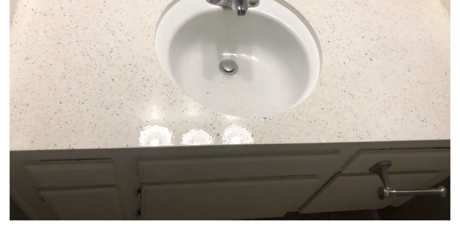 After: Yellowed dated vanity counter and sink before refinishing beside the refinished speckled counter