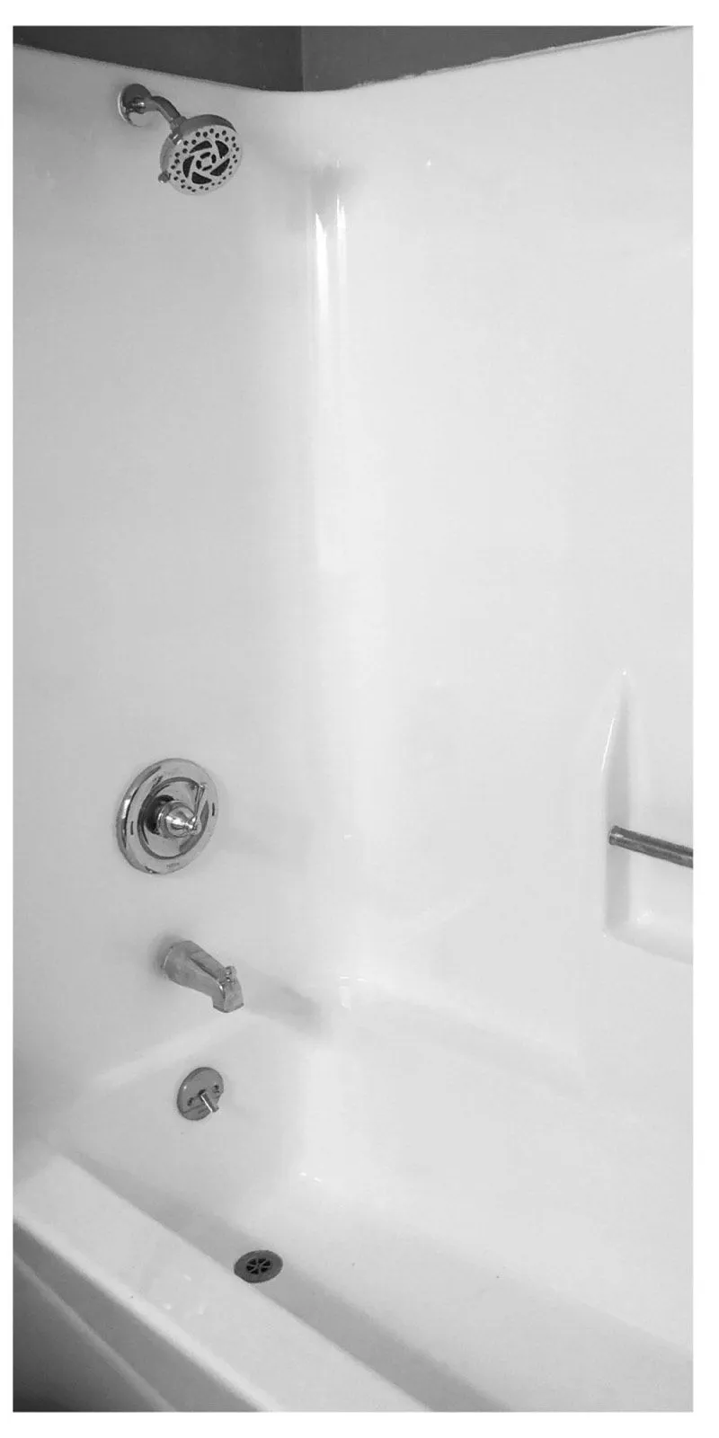After: Tub with rust patches and missing fixtures before refinishing beside the same tub refinished in white with new chrome