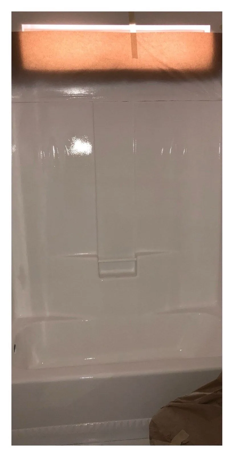 After: Dull hazy shower wall before refinishing beside the same wall refinished in gloss white