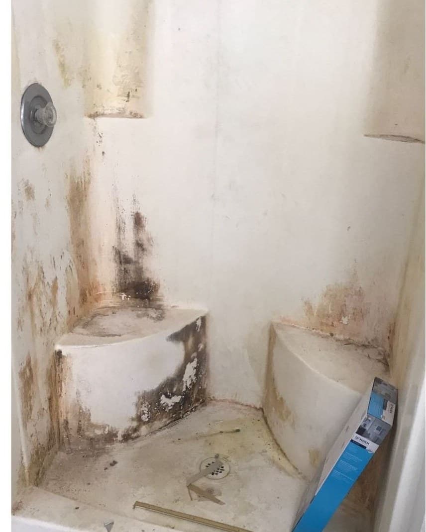 Mold-damaged tile shower stall before refinishing