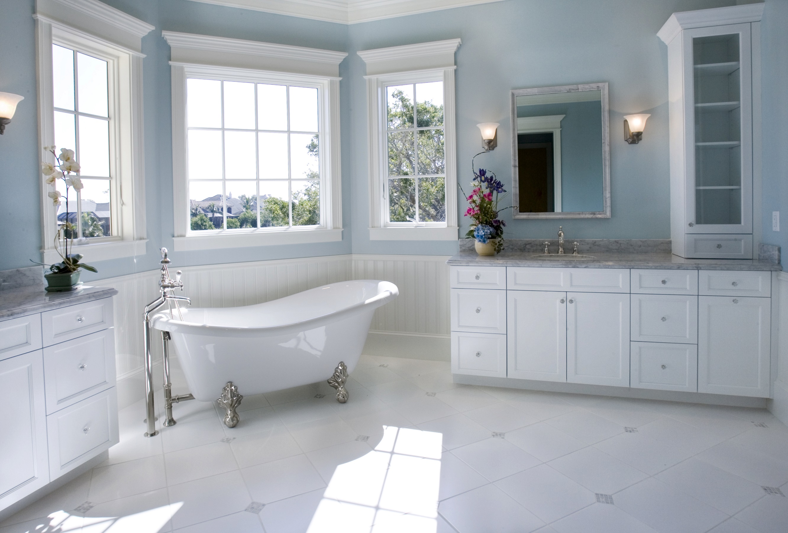 Bathroom with French windows and stand alone bathtub with metal legs.