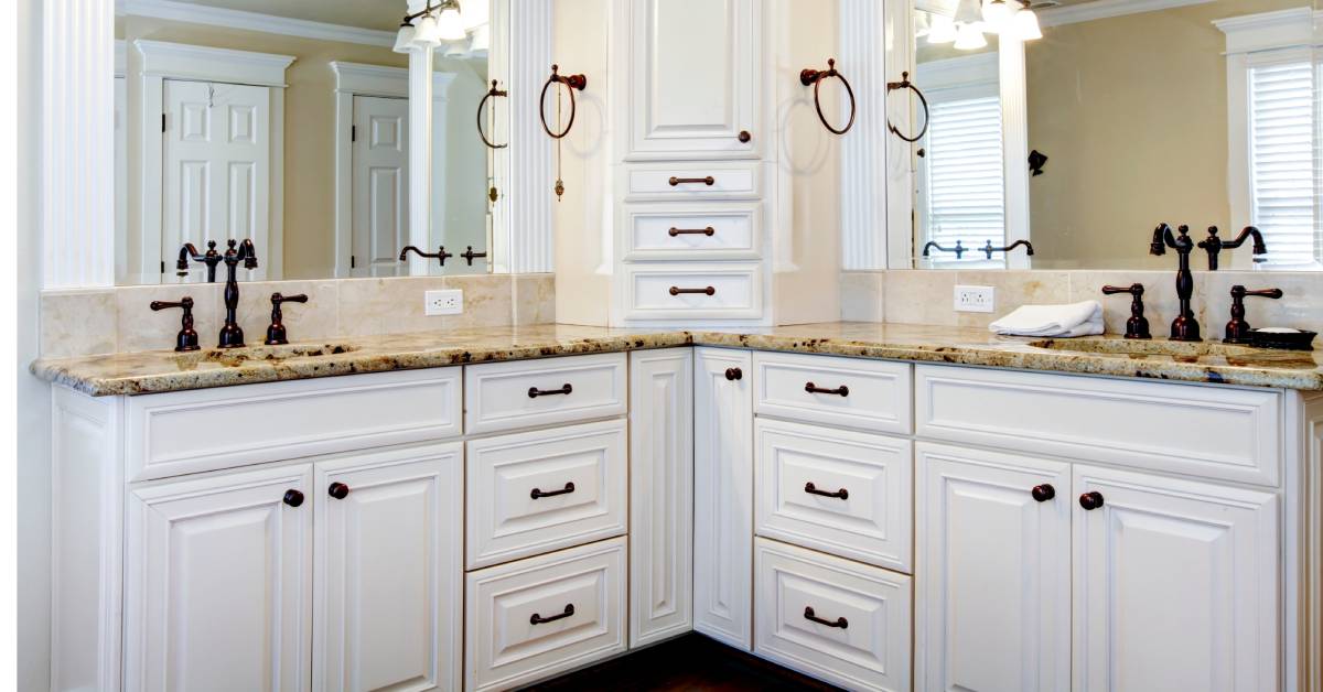 A luxury bathroom with a double vanity, two sinks and mirrors, and stunning white cabinets that look fresh and new.
