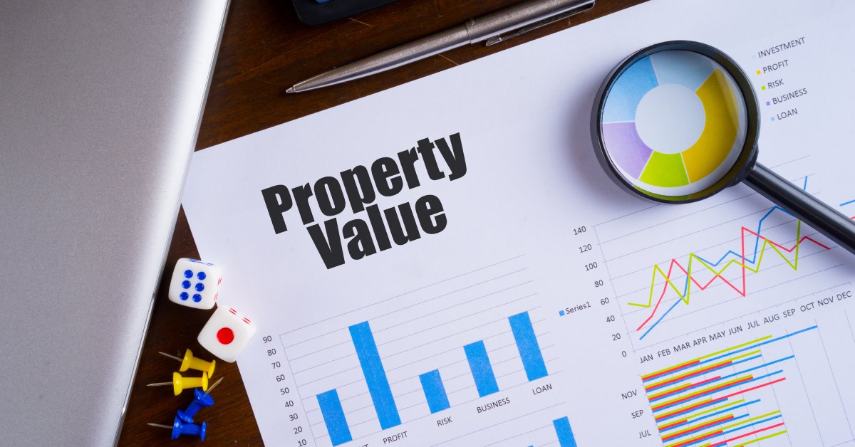 Closeup of a white paper with several graphs on it that says “property value” in large black text at the top.