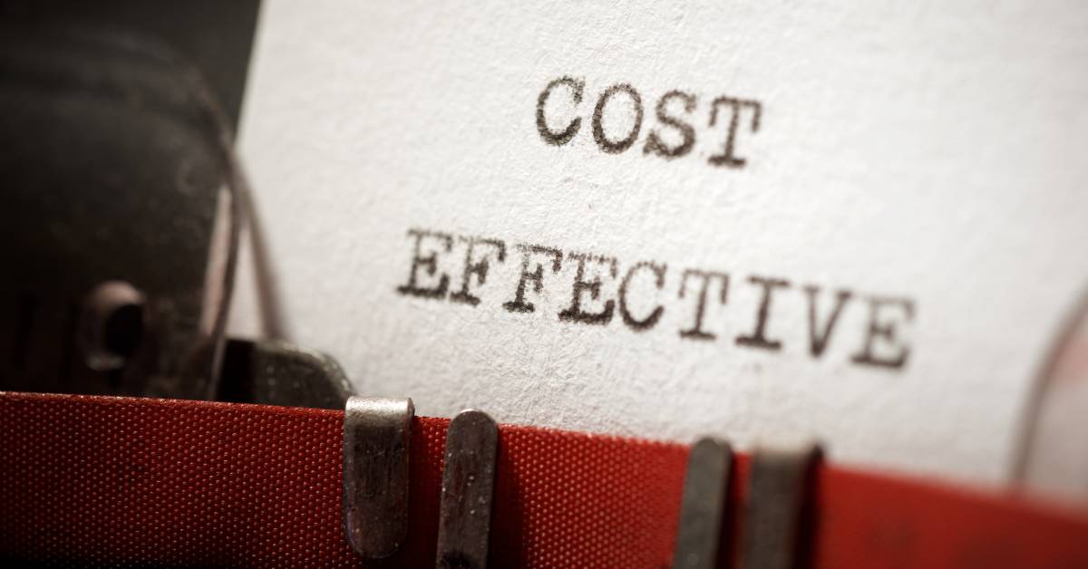 Closeup of a piece of paper in a typewriter with the large words “cost effective” typed in black on the front.