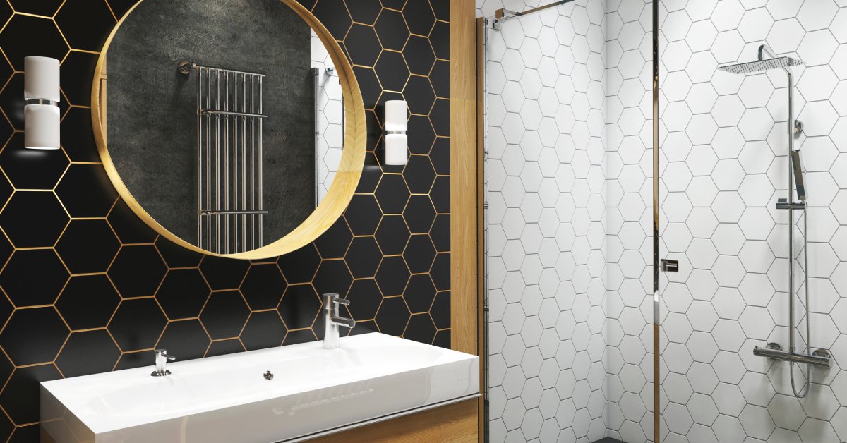 A modern bathroom with black and gold honeycomb wall tiles, white hexagon shower tiles, a circular mirror, and a vanity.